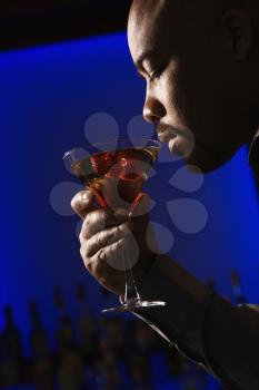Royalty Free Photo of a Man Drinking a Martini at a Bar