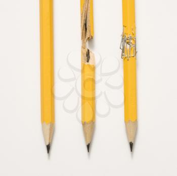 Royalty Free Photo of a Wooden Yellow Pencil Broken and Stapled Back Together