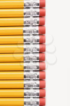 Eraser ends of group of pencils lined up in an even row. 