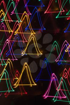 Multicolored lights forming abstract triangle pattern from motion blur.