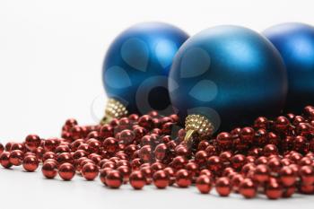 Royalty Free Photo of a Still Life of Blue Christmas Ornaments and Strings of Red Beads