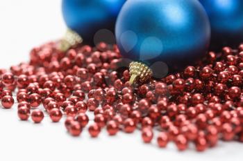 Royalty Free Photo of a Still Life of Blue Christmas Ornaments and Strings of Red Beads