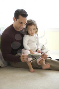 Royalty Free Photo of a Father Reading a Book to His Daughter