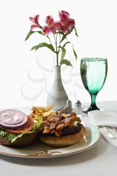 Royalty Free Photo of a Cheeseburger Meal With Flowers and a Glass of Water
