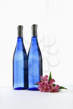 Royalty Free Photo of Two Bottles With Astremeria Flowers