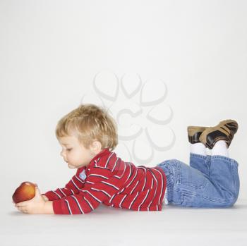 Royalty Free Photo of a Toddler Boy Holding an Apple