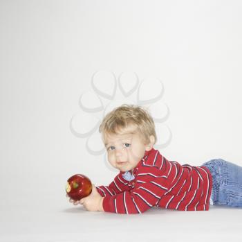 Royalty Free Photo of a Toddler Boy Holding an Apple