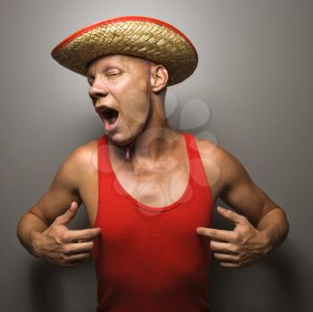 Royalty Free Photo of a Male Wearing a Straw Hat and Touching His Chest