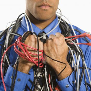 African American businessman wrapped in computer cables.