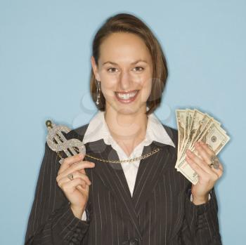 Royalty Free Photo of a Businesswoman Smiling Holding Money and Wearing a Necklace With an Over-sized Dollar Sign