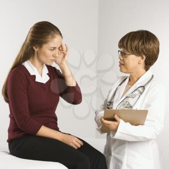 Royalty Free Photo of a Doctor Listening to a Patient Explain Her Symptoms
