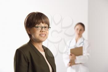 Royalty Free Photo of a Patient Smiling With a Doctor in the Background