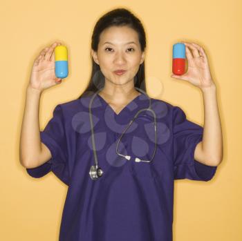 Royalty Free Photo of a Female Doctor Holding Up Giant Pills
