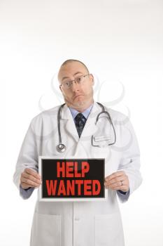 Royalty Free Photo of a Doctor Holding a Help Wanted Sign