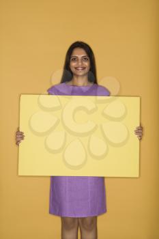 Pretty mid adult Indian woman holding blank sign.