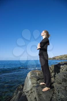 Royalty Free Photo of a Woman Standing on Hawaiian Coast Meditating