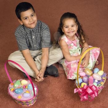 Royalty Free Photo of a Brother and Sister Sitting on a Floor With Easter Baskets Smiling