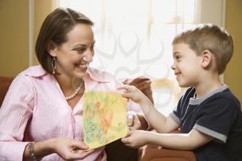 Royalty Free Photo of a Boy Giving His Mother a Drawing