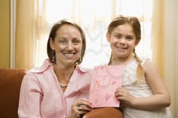 Royalty Free Photo of a Girl Giving Her Mother a Drawing