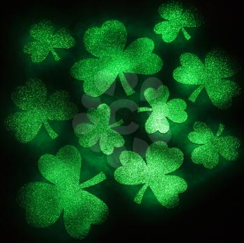 Royalty Free Photo of a Group of Green Shamrocks Reflecting Light on a Black Background