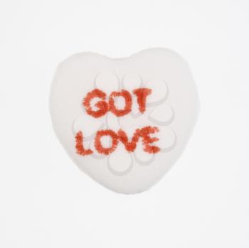 White candy heart that reads got love against white background.