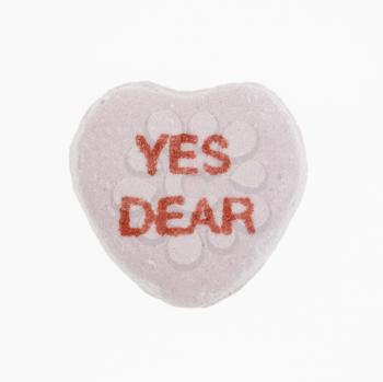 Purple candy heart that reads yes dear against white background.