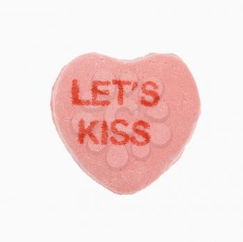 Royalty Free Photo of an Orange Candy Heart That Reads Let's Kiss