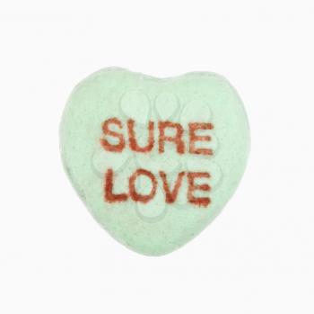 Royalty Free Photo of a Green Candy Heart That Reads Sure Love