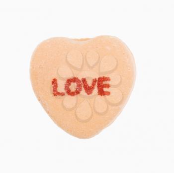 Royalty Free Photo of Orange Candy Heart That Reads Love