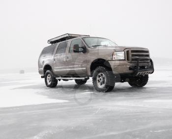 Royalty Free Photo of a Four Wheel Drive Truck With All Terrain Tires and Roof Rack Parked on Desolate Frozen Lake in Green Lake, Minnesota, USA
