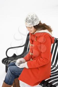 Royalty Free Photo of a Woman Sitting on a Park Bench Using PDA