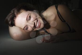 Royalty Free Photo of a Woman Laying on the Floor Smiling