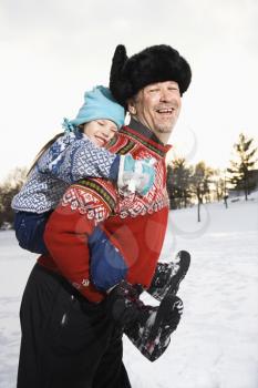 Royalty Free Photo of A Middle-aged Man Giving a Little Girl a Piggyback Smiling