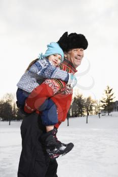 Royalty Free Photo of a Middle-Aged Man Giving a Little Girl a Piggyback Smiling