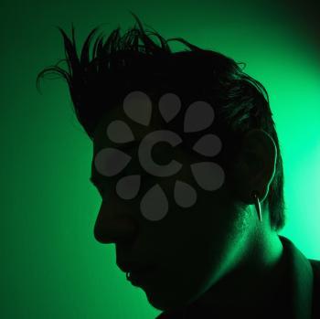 Royalty Free Photo of a Side View Silhouette of a Young Man Against a Green Background