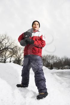 Royalty Free Photo of a Boy Standing Holding a Snowboard in the Snow