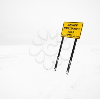 Royalty Free Photo of a Minimum Maintenance Road Sign in a Deserted Winter Blizzard