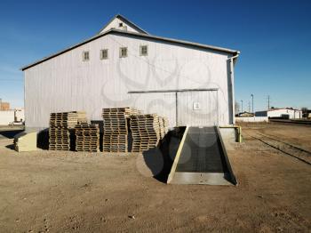 Royalty Free Photo of a Storage Warehouse With Ramp and Palettes in a Rural Setting