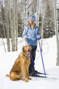 Royalty Free Photo of a Woman Skiing With a Golden Retriever