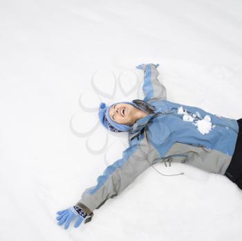 Royalty Free Photo of a Woman Laying Making a Snow Angel