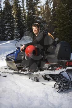 Royalty Free Photo of a Man Sitting on a Snowmobile Smiling