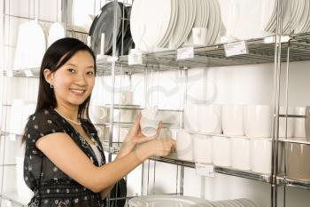 Royalty Free Photo of a Woman Shopping for Dishes and Glasses in a Retail Store