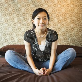 Royalty Free Photo of a Female Sitting on a Bed Smiling