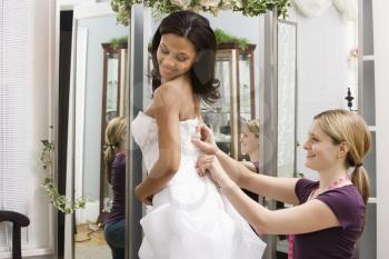 Royalty Free Photo of a Seamstress Helping a Bride in a Bridal Shop