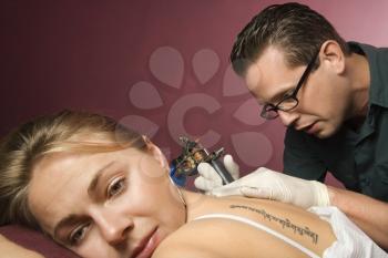 Royalty Free Photo of a Man Tattooing a Woman
