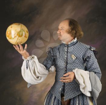 Royalty Free Photo of a William Shakespeare in Period Clothing Holding a Spinning Globe