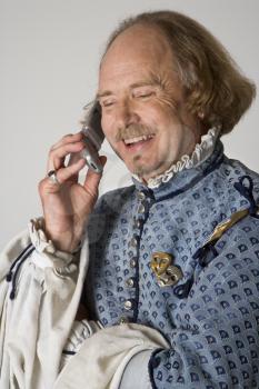 Royalty Free Photo of William Shakespeare in Period Clothing Talking on a Cellphone and Laughing