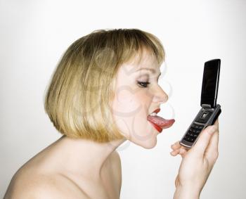 Royalty Free Photo of a Blonde Woman About to Lick Her Cellphone