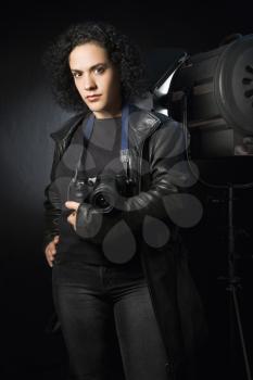 Royalty Free Photo of a Woman holding digital camera in studio setting.