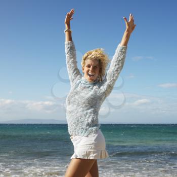 Royalty Free Photo of an Attractive Woman Smiling With Her Arms Raised in the Air on Maui, Hawaii Beach